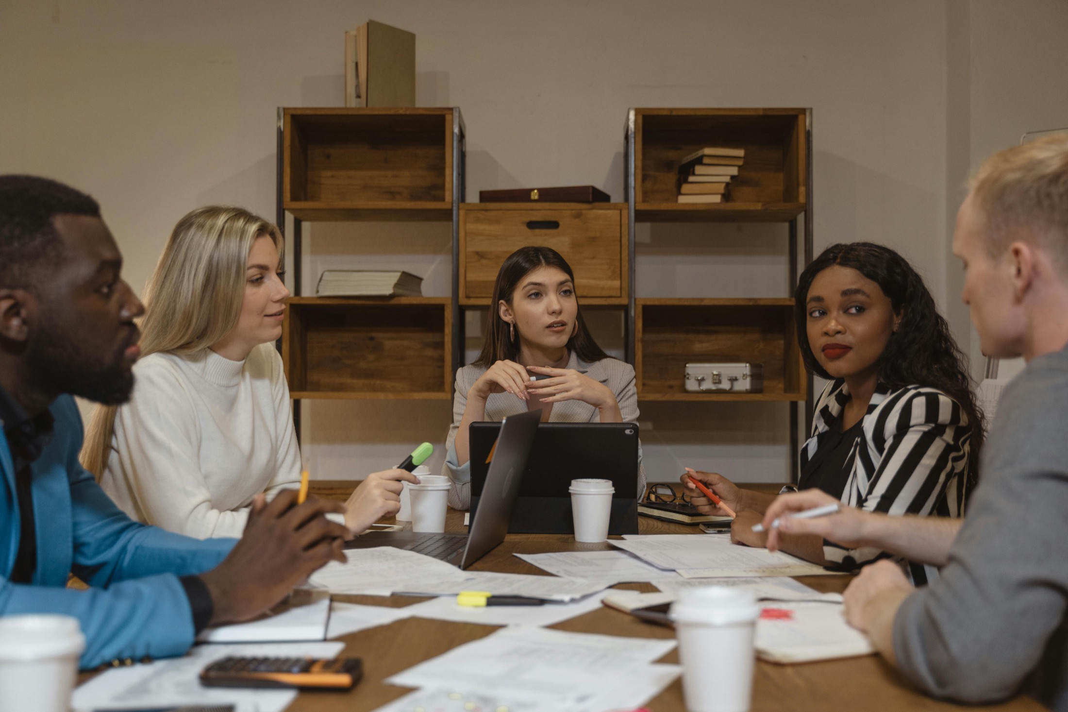 Legal and compliance team reviewing documents around a desk.